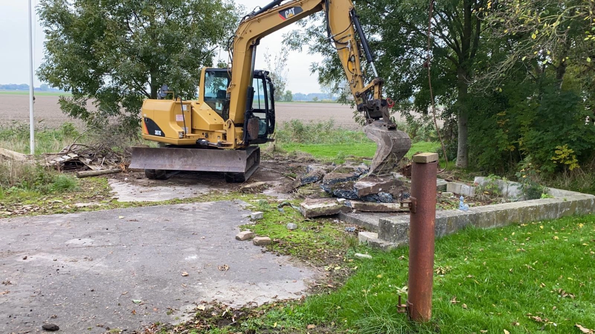 Graafmachine breekt een betonnen vloer op tijdens klein sloopwerk